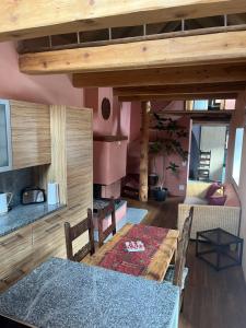a dining room with a wooden table and a kitchen at Casa Viola in Piano