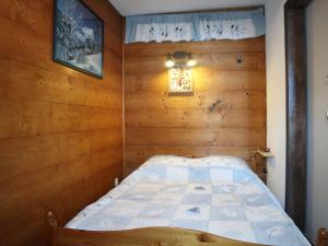 una camera con un letto su una parete in legno di Appartement Les Orres, 2 pièces, 6 personnes - FR-1-322-568 a Les Orres