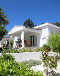 a white house with chairs in front of it at Residence Vogt in Poreč