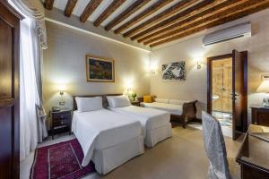 a bedroom with a large white bed and a couch at Ca' Del Nobile in Venice