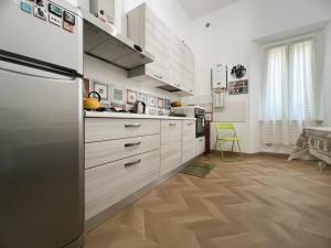 een keuken met witte kasten en een koelkast bij A casa di Ala in Rome