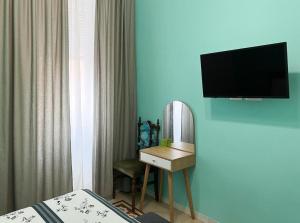 een hotelkamer met een spiegel en een televisie bij A casa di Ala in Rome