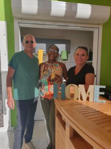a man and two women standing in front of a table at Jeune Tournesol (Bungalow neuf) in Sainte-Anne