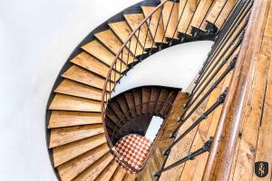 uma escada em espiral num edifício com uma escada de madeira em La Casa Naia V — Votre bulle d'air sur la côte em Douvres-la-Délivrande