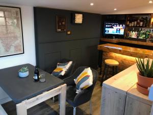 eine Bar mit einem Sofa, einem Tisch und einer Theke in der Unterkunft El Nido - Self Catering cabin in Southbourne, 5 mins from beach in Iford
