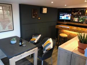 um bar com um sofá, uma mesa e um balcão em El Nido - Self Catering cabin in Southbourne, 5 mins from beach em Iford