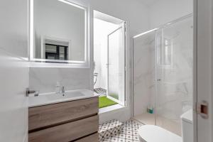 ein weißes Bad mit einem Waschbecken und einer Dusche in der Unterkunft Apartamentos Pino in Benidorm