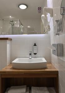 uma casa de banho com um lavatório branco e um espelho. em Vestil Hotel em Piotrków Trybunalski