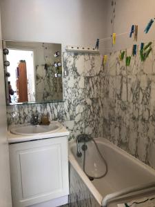 a bathroom with a sink and a tub and a mirror at Le grand calme à deux pas de Paris in Neuilly-sur-Seine