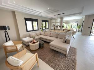 uma sala de estar com um sofá e uma mesa em NEW LUXURY VILLA : 7 BEDROOMS : POOL : GYM : SPA em Marbella