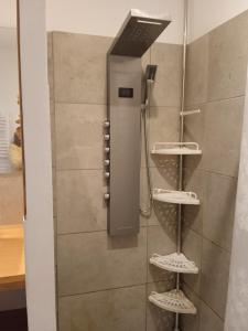 La salle de bains est pourvue d'une douche et de 3 étagères. dans l'établissement le clos du ventoux, à Malaucène