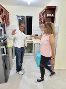 een man en een vrouw die in een keuken staan bij SUISSE . CH APPARTEMENT in San Pedro de Macorís