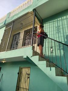 een vrouw die op de trap van een gebouw staat bij SUISSE . CH APPARTEMENT in San Pedro de Macorís