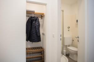 een badkamer met een toilet en een zwarte jas bij Deluxe Studio - City Center - 5 Min to Slopes - Am Kurpark in Winterberg