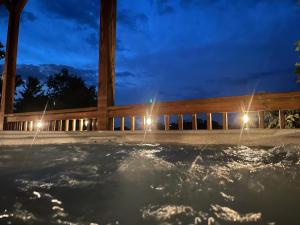 uma banheira de hidromassagem à noite com uma cerca de madeira em Rustic Cabin, Fire Pit with HotTub, Mountain Views, Peaceful Location em Sevierville