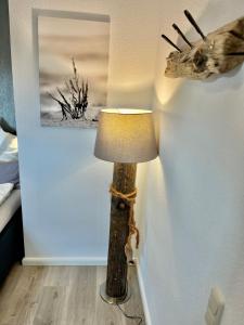 una lámpara en una habitación con una foto en la pared en Hof Steinhütten, en Westerhever
