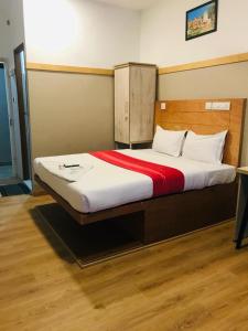 a bedroom with a large bed with a red blanket at Rio Rooms Calicut in Kozhikode