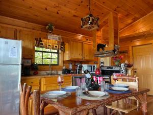 a wooden kitchen with a table and a refrigerator at Rustic Cabin, Fire Pit with HotTub, Mountain Views, Peaceful Location in Sevierville