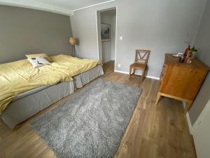 1 dormitorio con cama, mesa y alfombra en Kolmården, Generös villa en Kolmården