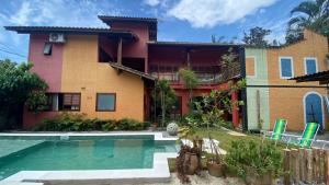 una casa con una piscina di fronte di Pousada Preamare a Ubatuba