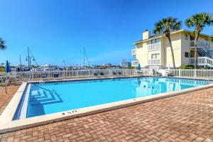 a swimming pool with palm trees and a building at ​Sandpiper cove in Destin