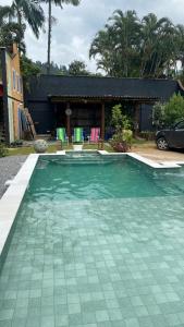 una piscina con sedie e una casa di Pousada Preamare a Ubatuba