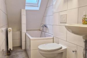 a white bathroom with a toilet and a sink at Apartments Leverkusen in Leverkusen