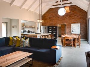 ein Wohnzimmer mit einem blauen Sofa und einem Tisch in der Unterkunft Star Dam Lodges in Dargle