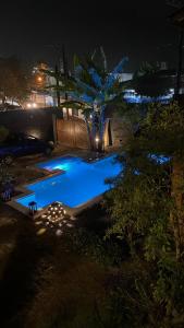 una piscina en un patio por la noche en Pousada Preamare en Ubatuba