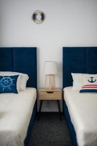 two beds with blue headboards in a room at Willa ALBATROSA 9 in Władysławowo