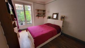 a bedroom with a bed with a purple blanket at Le grand calme à deux pas de Paris in Neuilly-sur-Seine