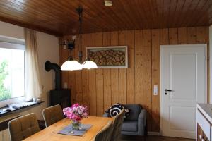 a dining room with a table with flowers on it at Ferienhaus Schau ins Land - eigene Panorama-Sauna in Schöfweg