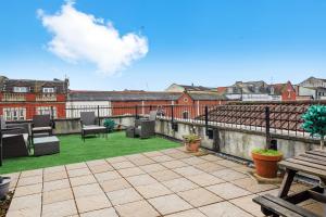 a patio with chairs and tables on a roof at Beautiful Duplex with Private Rooftop - Sleeps 6 in Bristol