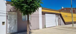 een gebouw met twee garagedeuren en een palmboom bij El jacaranda Alojamiento Diario in San Luis