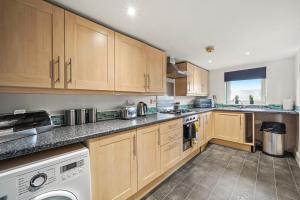 a kitchen with wooden cabinets and a dishwasher at Beautiful Duplex with Private Rooftop - Sleeps 6 in Bristol