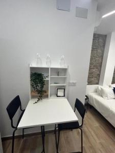 - une table et des chaises blanches dans une chambre avec un lit dans l'établissement Apartamentos Rocablanca, à Benidorm