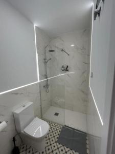 ein weißes Bad mit einer Dusche und einem WC in der Unterkunft Apartamentos Rocablanca in Benidorm