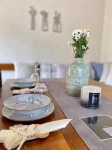 una mesa de madera con platos y un jarrón con flores en Kontos Village House, en Kondós