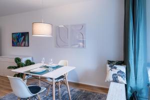 une salle à manger avec une table et des chaises blanches dans l'établissement MESSE und UNI-Nähe: Moderne Wohnung mit Parkplatz und Küche, à Augsbourg