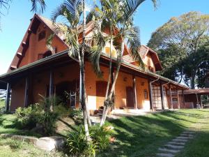 een huis met palmbomen ervoor bij Terra Rica Summer House in São Pedro