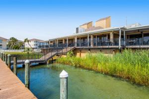a building next to a river with a dock at ​Sandpiper cove in Destin