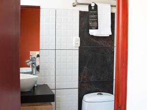 a bathroom with a toilet and a sink at Rua Hoteles Talara in Talara