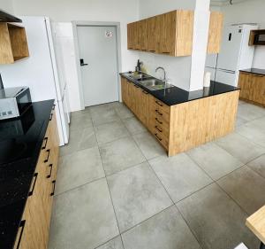 eine Küche mit Holzschränken und Fliesenboden in der Unterkunft StarBal in Radom