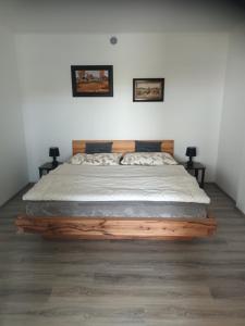 1 dormitorio con 1 cama de madera y 2 mesitas de noche en Apartmán-Znojmo, en Znojmo