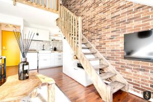 a brick walled kitchen and staircase in a loft at L'Atypique — Duplex de charme in Caen