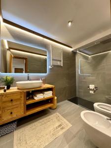 a bathroom with a sink and a toilet and a mirror at Cozy bilocale apartment in Breuil-Cervinia