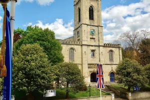 a church with a clock tower with a flag in front at Epic Location, Views & Large Private Terrace in Windsor