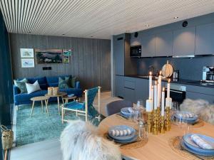 a kitchen and dining room with a table and a couch at Waterfront apartment with panoramic sea view in Henningsvær