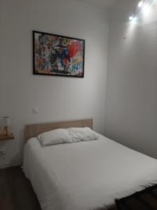 a bedroom with a bed and a painting on the wall at Home-Sweet-Home Superbe appartement en hypercentre in La Rochelle