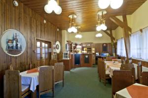 a restaurant with tables and chairs and wooden walls at Chata Lesanka in Jáchymov